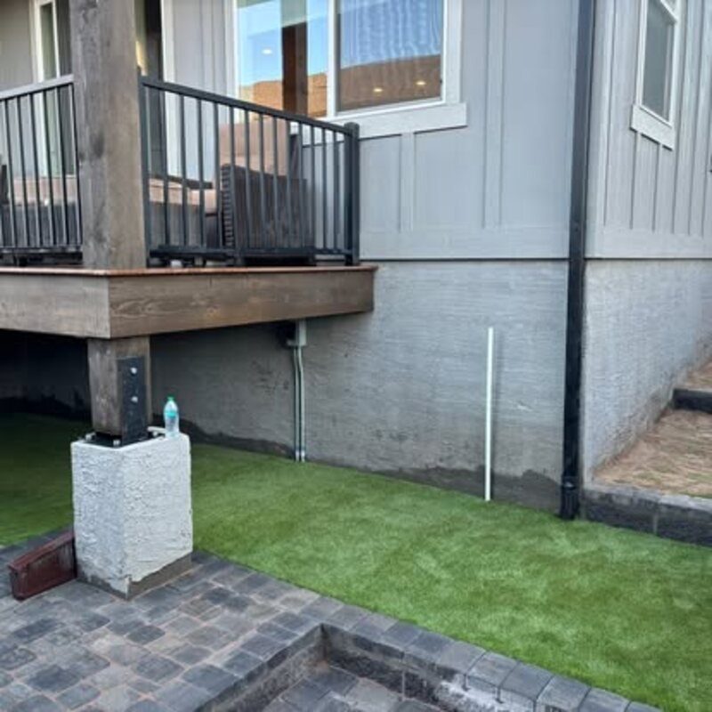 Artificial turf beside paver patio and deck